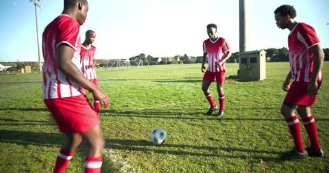 Teammates strategizing on soccer field, ready for play