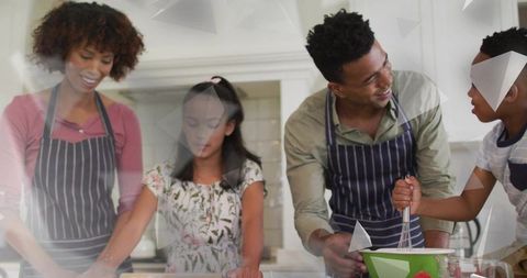 Family baking together in kitchen wearing aprons, parents teaching kids whisking dough