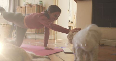 Woman Practicing Yoga While Playing with Her Dog at Home