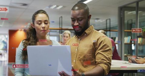 Young professionals collaborating over laptop in modern open-plan coworking space