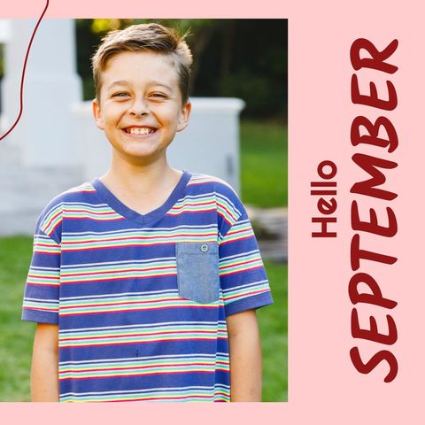 Smiling Boy Welcoming September in Vibrant Garden