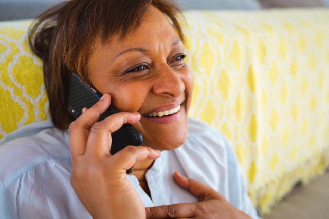 Happy african american senior woman talking on mobile phone while sitting at home - Download Free Stock Photos Pikwizard.com