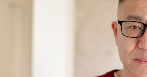 Senior Asian Man Wearing Glasses with Focused Expression in Office