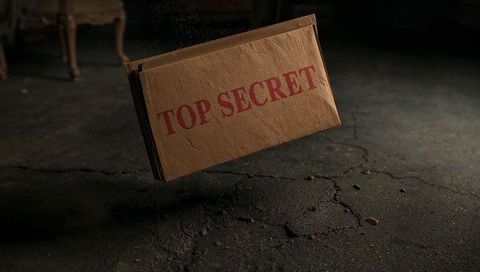 Floating top secret envelope hovering over cracked basement floor creating moody suspense