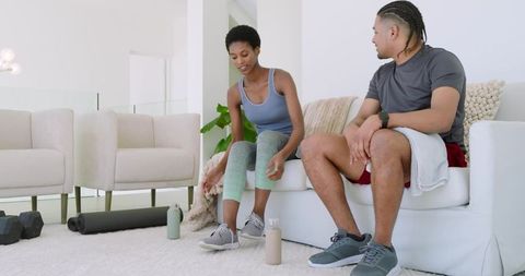 Diverse couple preparing for home fitness activity