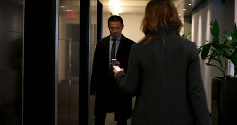 Business Professionals Using Mobile Phones by Hotel Elevator - Download Free Stock Images Pikwizard.com