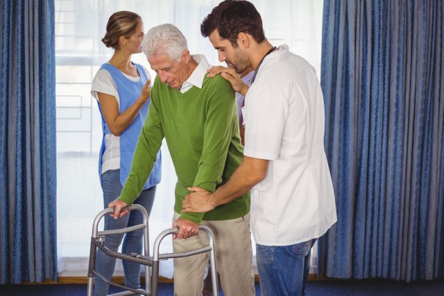 Nurse helping seniors walking with a walker in retirement house