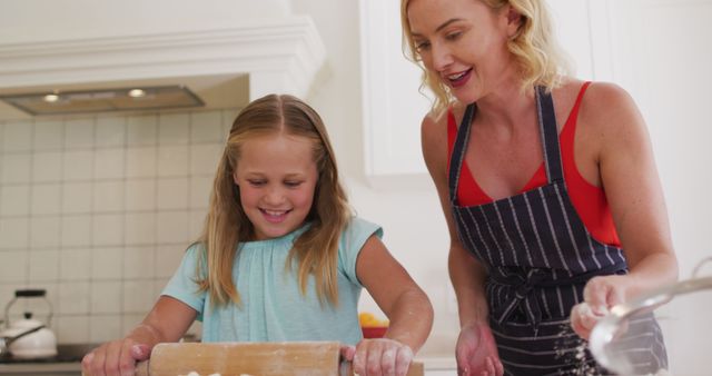 Caucasian mother and daughter baking together in the kitchen at home. family, love and togetherness concept