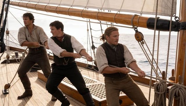 Three sailors hauling rigging on classic wooden schooner deck, teamwork at sea
