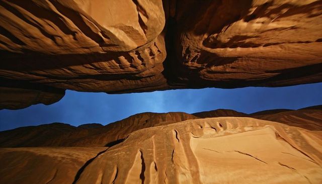 Sunlight illuminating narrow sky gap between towering sandstone walls