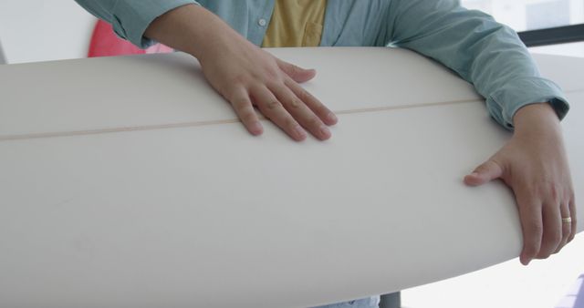 Man Holding Surfboard in Indoor Setting - Download Free Stock Images Pikwizard.com