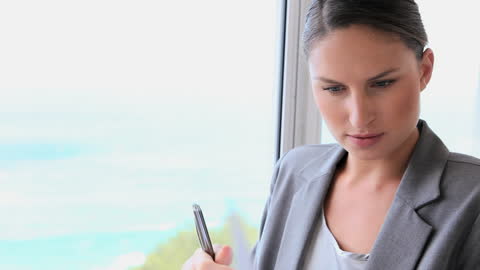 Businesswoman Contemplating While Holding Notebook by Window
