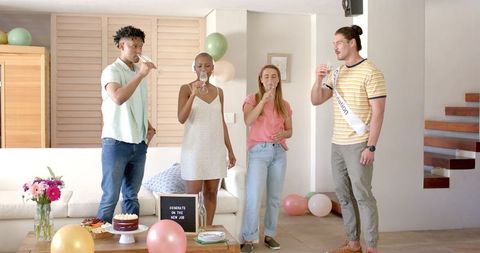 Friends celebrating new job at home with cake and champagne