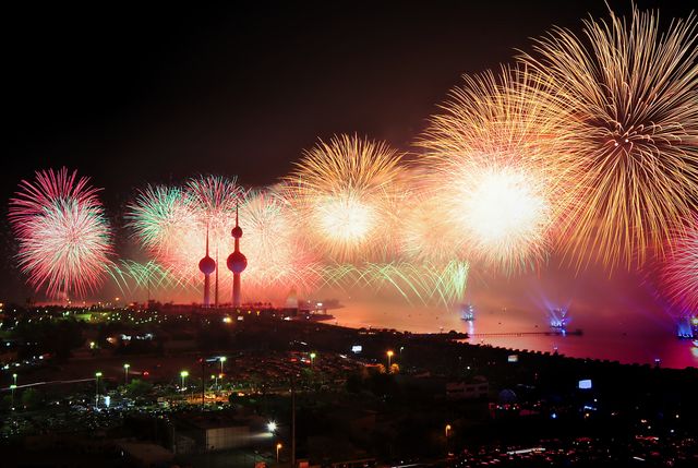 Bright and colorful fireworks lighting up the night sky over a bustling cityscape, creating an energetic and festive atmosphere. Suitable for use in projects related to celebrations, city festivities, New Year's Eve, Independence Day, and other large public events.