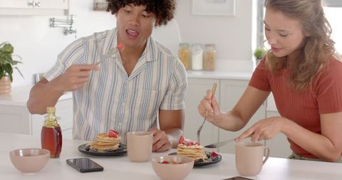 Couple Enjoying Breakfast with Pancakes and Strawberries