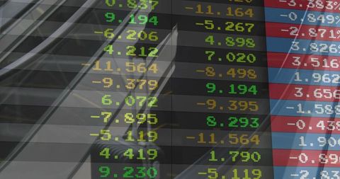 Neon market ticker reflecting on glass and escalator rails, showing multicolor stock digits
