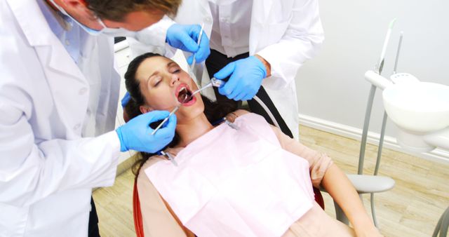 Dental Professionals Treating Female Patient with Open Mouth - Download Free Stock Images Pikwizard.com