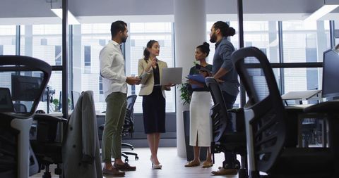 Professionals gather in a modern office space for a strategic discussion, highlighting themes of diversity and teamwork.