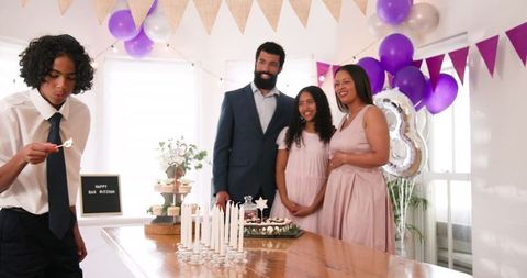 Family celebrating traditional ceremony with candles at home