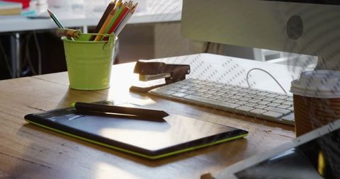 Digital drawing tablet with stylus on wooden desk in bright home studio workspace