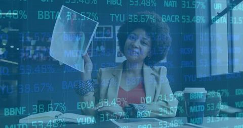 Businesswoman analyzing data with financial overlay in modern office