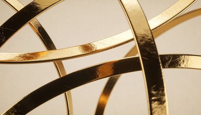 Glinting polished gold bands forming woven arcs luxury metallic sculpture on warm beige backdrop