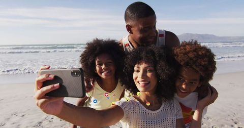 Family Enjoying Beach Day Taking Selfie by Ocean Waves