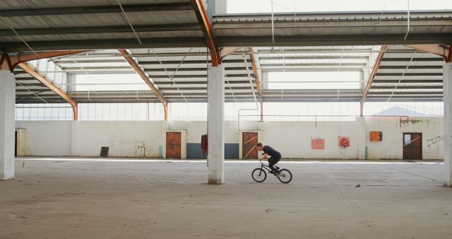 BMX Rider Practicing Stunts in Empty Warehouse - Download Free Stock Images Pikwizard.com