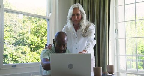 Couple Collaborating on Laptop at Home Near Window