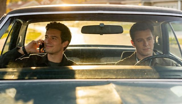 Two men chatting in classic sedan at golden hour, driver navigating quiet suburban street