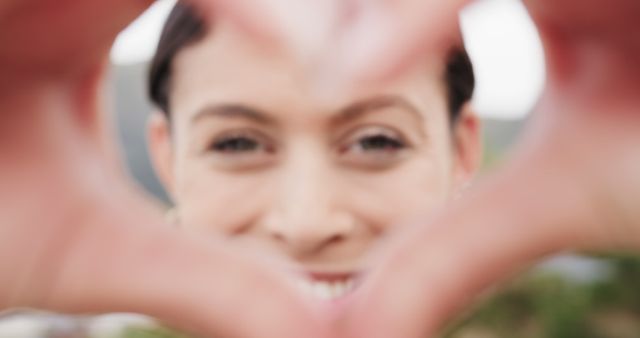 Person Framing Face With Heart-Shaped Hands in Soft Focus - Download Free Stock Images Pikwizard.com