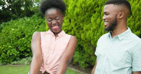 Surprised woman receiving proposal from boyfriend in park