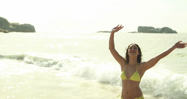 Smiling young woman stretching arms on the beach - Download Free Stock Photos Pikwizard.com