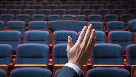 Empty auditorium with hand raised in formal attire