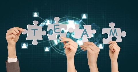 Hands Holding TEAM Puzzle Pieces in Futuristic Digital Interface