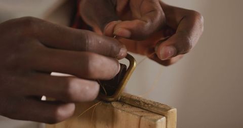 Craftsman preparing leather belt with traditional tools