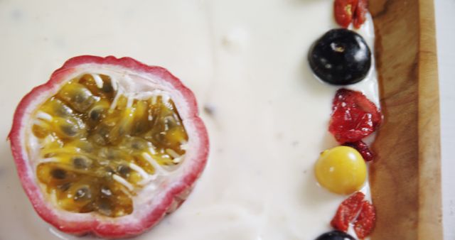 Passion fruit in creamy dessert accompanied by mixed berries, including red berries, grape, and yellow cherry. Ideal for showcasing exotic desserts and fresh, healthy eating concepts. Perfect for blogs, menus, and food-related promotions.