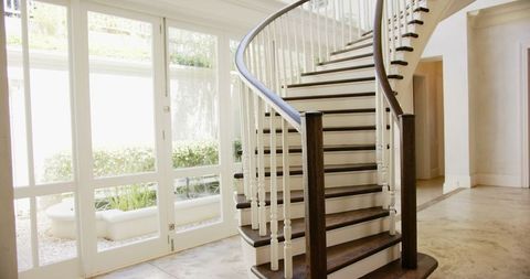 Luxurious spiral staircase in sunlit modern home