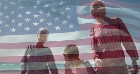 Senior couple and grandchild walking on sunny beach with translucent american flag overlay