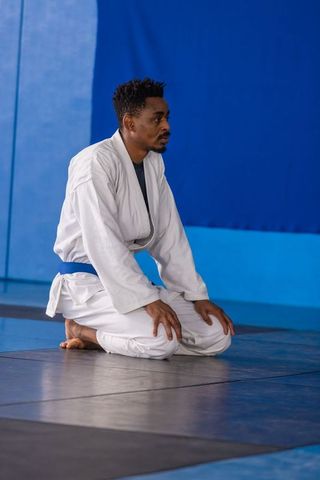Martial Artist Kneeling in Training Hall