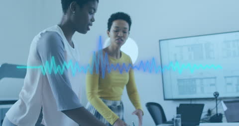 Diverse Businesswomen Analyzing Sound Data Interface in Office