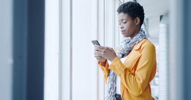 Young Woman Using Smartphone Near Large Windows - Download Free Stock Images Pikwizard.com