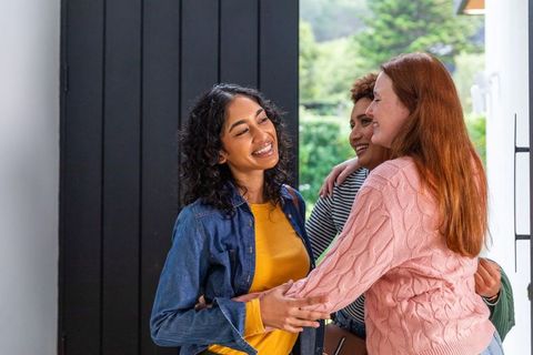 Diverse Female Friends Hugging at Home Entryway