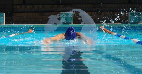 Woman swimming butterfly stroke in outdoor pool, splashing lane ropes and mirrored reflection