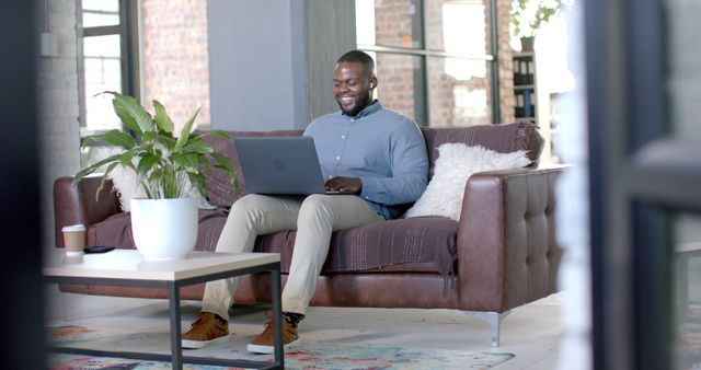 Young professional working on laptop in modern living room - Download Free Stock Images Pikwizard.com