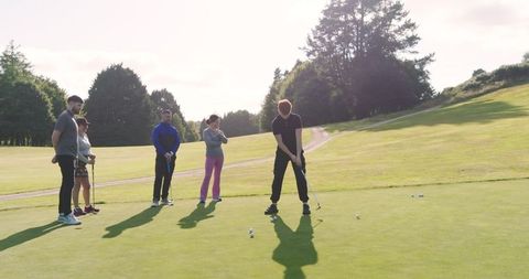 Friends Enjoying Golf in Bright Sunshine on Putting Green