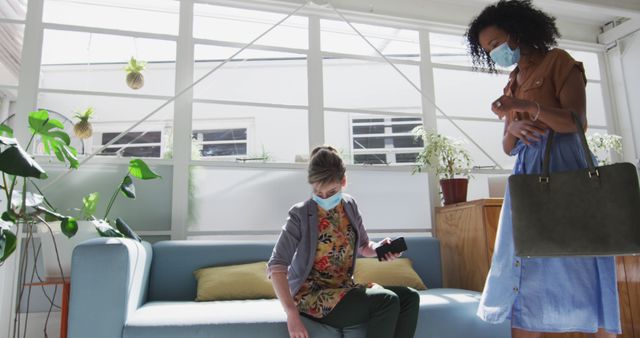 Two Women Wearing Masks in Home Interior with Plants - Download Free Stock Images Pikwizard.com