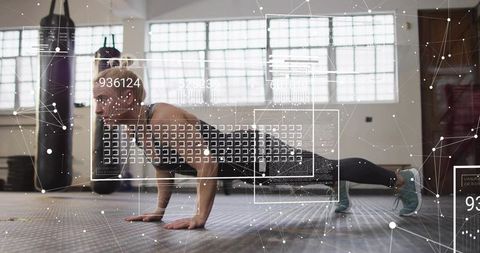 Holding high plank in industrial gym with digital fitness overlay and data hud