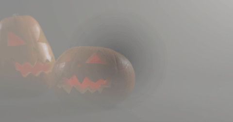 Foggy jack o lanterns emitting warm candlelight glow with misty copy space