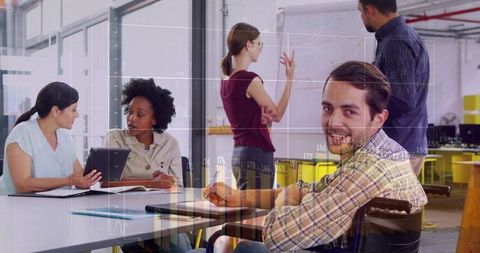 Smiling wheelchair professional collaborating in open-plan office meeting with analytics